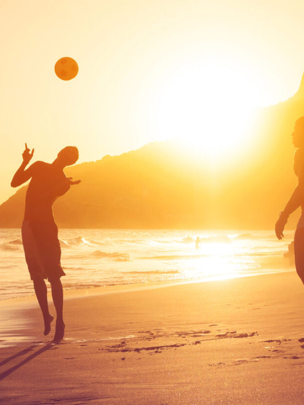 Ragazzi giocano a pallone al tramonto sulle spiagge brasiliane