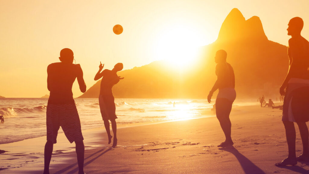 Ragazzi giocano a pallone al tramonto sulle spiagge brasiliane