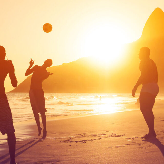 Ragazzi giocano a pallone al tramonto sulle spiagge brasiliane
