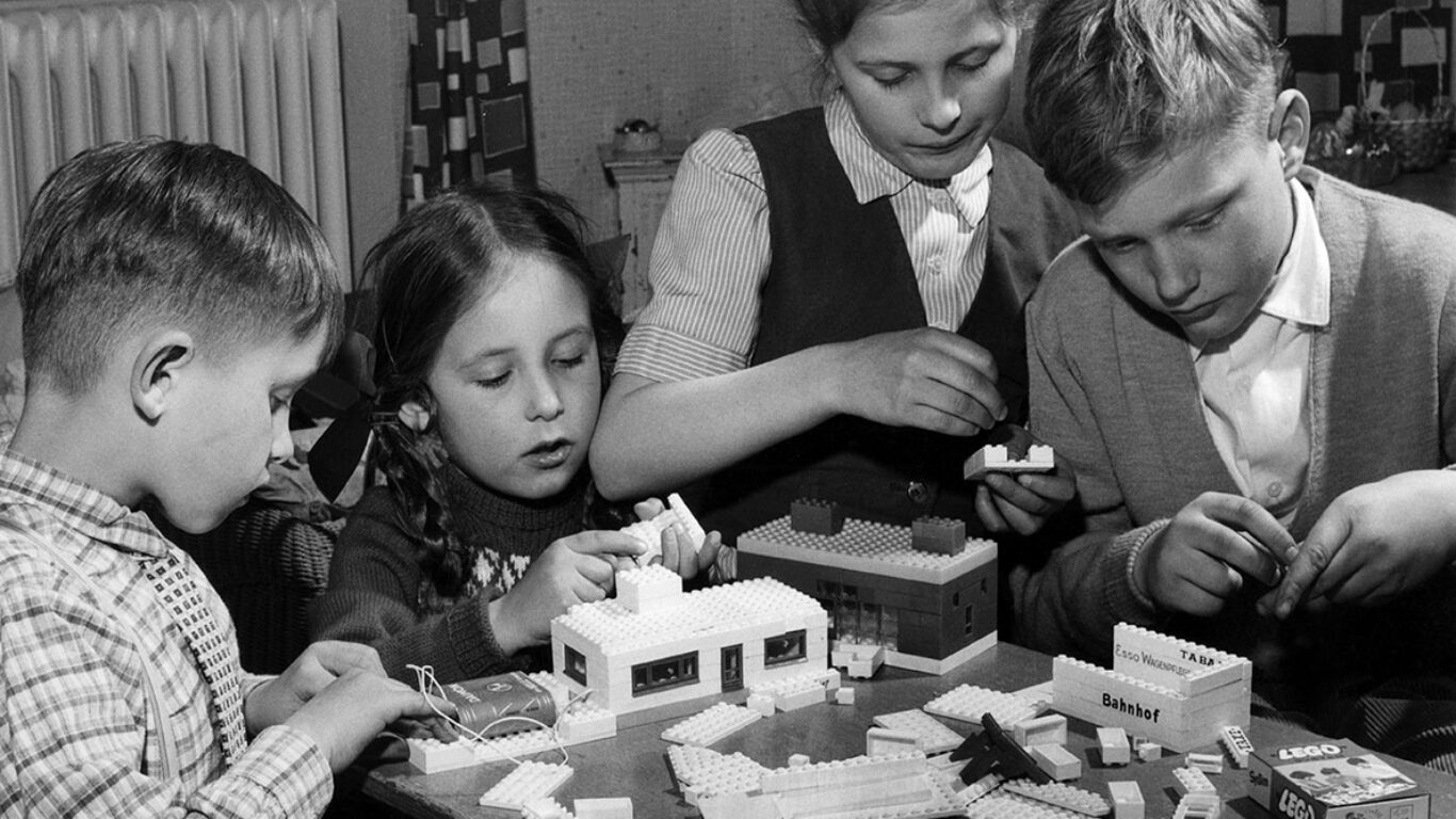 Quattro bambini giocano con le costruzioni.