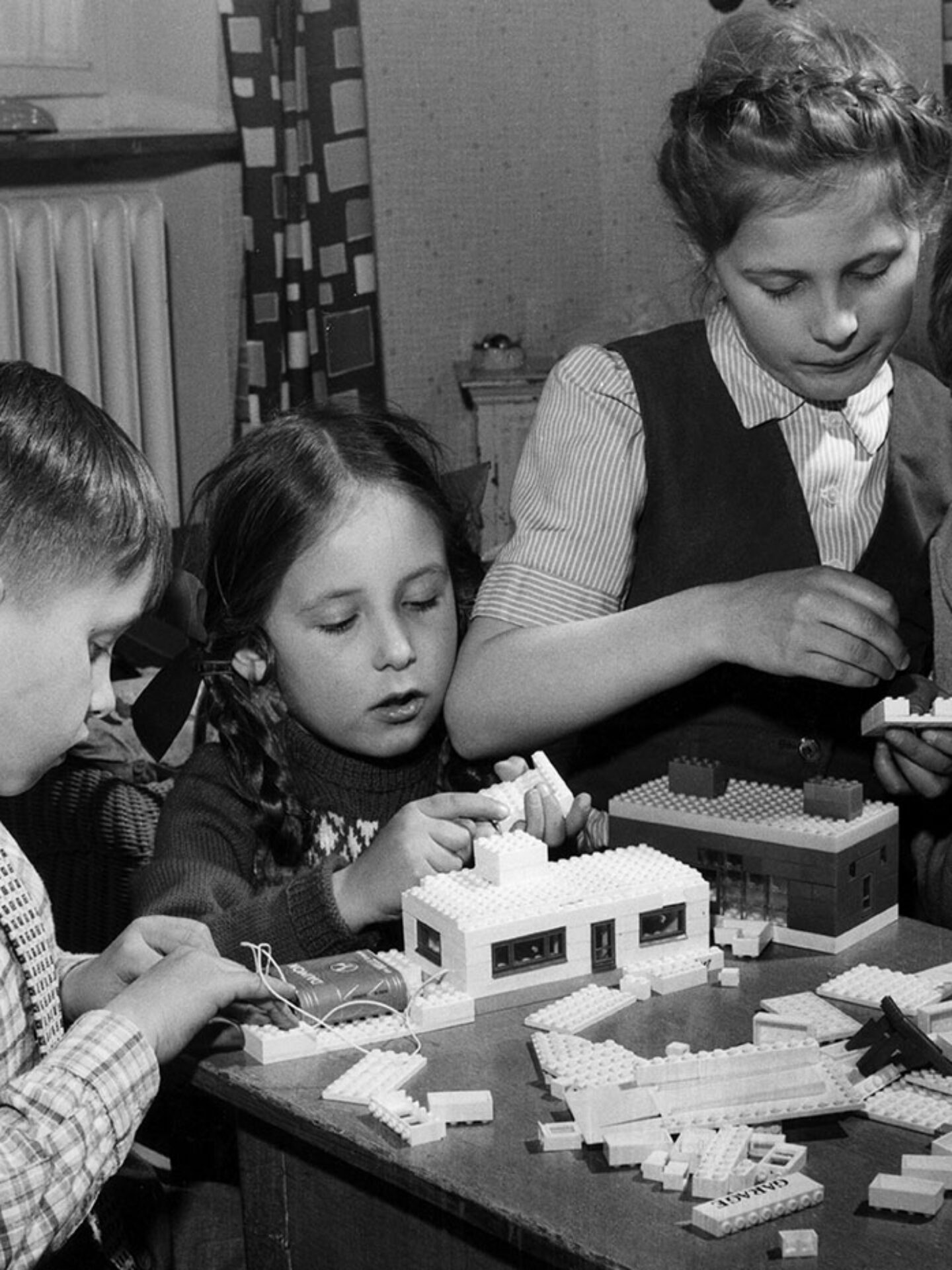 Quattro bambini giocano con le costruzioni.