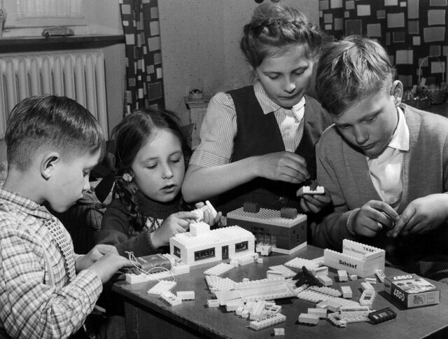 Quattro bambini giocano con le costruzioni.